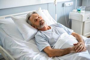 Patient resting in a hospital bed, sleeping calmly with medical equipment around in a hospital room. photo