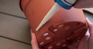 Redecorating of flower pot using glue and burlap. Process of transforming a simple flower pot with burlap, creating beautiful home decor. Perfect for garden lovers and crafters alike. video