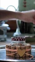 Fingers hold candle at wick and put candle inside handcrafted candle holder made from jam jar with used wine corks. Female hands light up candlelight. Recycled home decor. Vertical format video