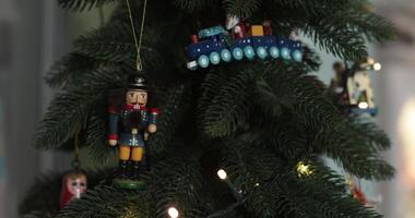 Explore charming Christmas home decor with beautifully hung nutcracker ornaments on a lush pine tree. The festive atmosphere is enhanced by twinkling lights and colorful decorations. video