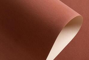 Terracotta velvet like paper background with a soft, matte texture and elegant folds. Reddish brown photo