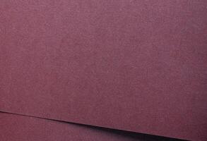 Metallic burgundy paper background with smooth, shimmering layers and subtle folds. Featuring deep, photo