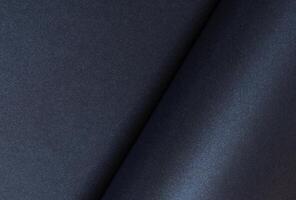 Dark blue rolled paper background with a smooth, shiny surface. Elegant and minimalist design with photo