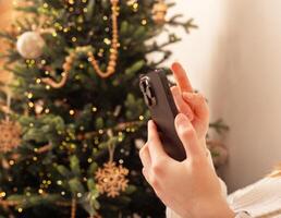 Lodz Poland July 20 2024, hands holding and using mobile phone, iphone smartphone on Christmas photo