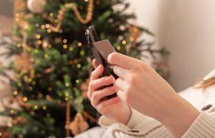 Lodz Poland July 20 2024, hands holding and using mobile phone, iphone smartphone on Christmas photo