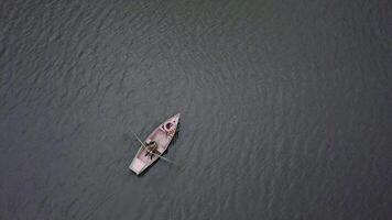 A peaceful and serene rowboat gently floats on calm and tranquil waters, embodying relaxation. Stock Clip photo