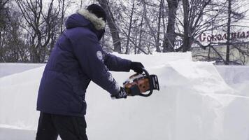 Man uses a chainsaw to efficiently clear heavy snow in winter photo