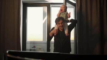 Father is teaching his little daughter how to make noise like war cry. Girl is sitting on his shoulders, having fun and enjoying activity. video