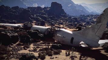 Plane wreckage lying amidst rocky terrain after a crash near mountains video