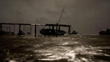 Dark waters reflect a weathered fishing dock in quiet surroundings at dusk video