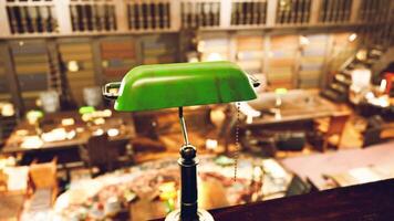 Old library interior featuring green desk lamp and scattered books video