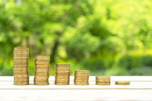 Business concept. Coins on a wooden table with green bokeh background. Business ideas, business success. Recovery and business growth. Copy space. photo