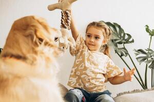 Cute beautiful little girl playing training dog golden retriever. Animal, executing commands concept photo