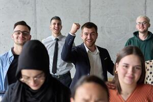 A diverse team of business professionals ecstatically celebrating their success in a modern office, expressing triumph and unity after achieving their goals photo