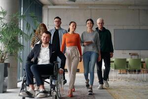 A diverse group of business professionals walking together through the office, symbolizing unity and strength as a collaborative and successful team photo
