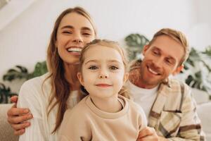 Smiling, happy family, beautiful mother, attractive father and little daughter embracing photo