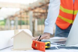 inspector or engineer is inspecting construction and quality assurance new house using a blue print. Engineer or architects or contactor work to build the house before handing it over to the homeowner photo