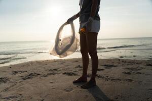 Save water. Volunteer pick up trash garbage at the beach and plastic bottles are difficult decompose prevent harm aquatic life. Earth, Environment, Greening planet, reduce global warming, Save world photo