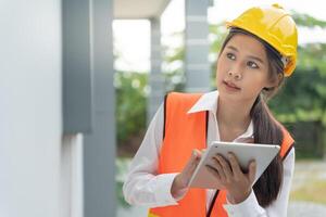 inspector or engineer is inspecting construction and quality assurance new house using a tablet. Engineers or architects or contactor work to build the house before handing it over to the homeowner photo