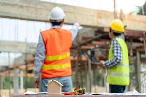 inspector or engineer is inspecting construction and quality assurance new house using computer. Engineers or architects or contactor work to build the house before handing it over to the homeowner photo