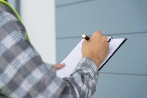 inspector or engineer is inspecting construction and quality assurance new house using a checklist. Engineers or architects or contactor work to build the house before handing it over to the homeowner photo