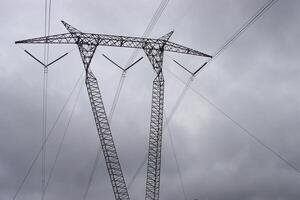 A large power line with a large tower in the sky photo