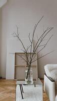 A vase with branches in it sitting on a table photo