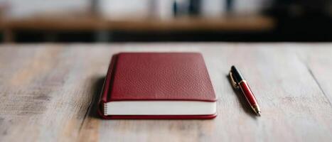 A red notebook and pen on a wooden table, symbolizing creativity and ideas. photo