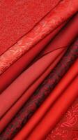 A collection of rich red fabrics showcasing various textures and patterns. photo