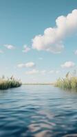 Serene waterway surrounded by lush grasses under a clear blue sky with fluffy clouds. photo
