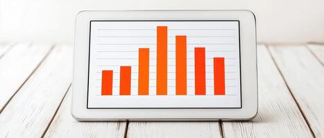 Digital tablet displaying a vibrant bar graph on a wooden surface. photo