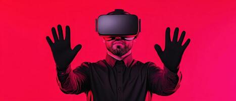 Man in virtual reality headset with hands raised against vibrant red background. photo