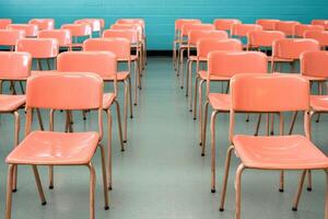 A row of empty chairs in a bright, modern classroom setting with colorful walls. photo