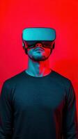 A man wearing virtual reality goggles in a vibrant red and blue setting. photo