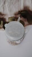 A plastic container with a lid on top of a white table photo