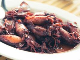Sauteed black squid is processed squid that is cooked until the squid ink is released. The resulting taste is very distinctive. photo