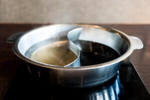 Hot pot three ways soup including original herb clear soup and black Sukiyaki soup. photo