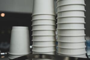 White paper coffee cup stacking in rows above coffee machine photo