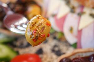 A CloseUp Image of a Flavorful Pickled Olive Resting on a Fork photo