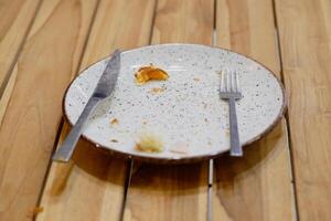 An empty dirty plate with a fork. photo