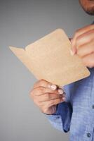 A hand is gracefully holding craft paper that features a minimalistic and elegant design photo