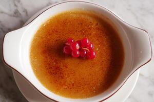 Caramel custard pudding on a plate on table photo