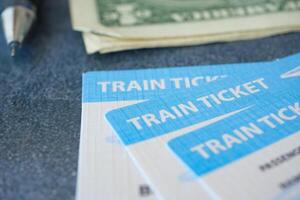 An assortment of train tickets and currency are placed on the table along with a pen photo