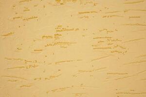 A beautifully textured yellow wall background showcasing subtle striations throughout it photo
