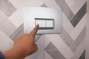 Stylish Modern Bathroom Tile Featuring a Convenient Toilet Flush Button for Easy Operation photo