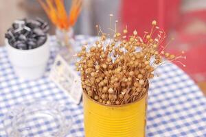 Beautiful and Charming Dried Floral Arrangement Presented in a Bright Yellow Can photo