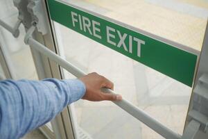 A person is using their hand to open a fire exit door for a vital emergency evacuation photo
