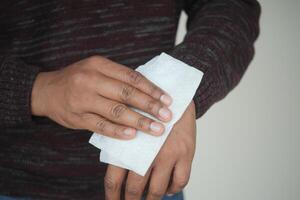 man disinfecting his hands with a wet wipe. photo