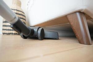 Utilizing a Vacuum Cleaner Under the Sofa for Highly Efficient and Thorough Cleaning photo