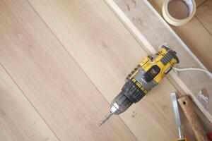 Using a Power Drill on a Wooden Floor for a Home Improvement Project and Renovation photo